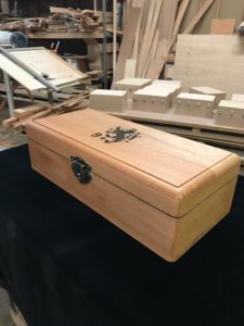 A wooden box with some metal handles on top of it