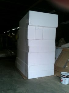 A large stack of boxes in the middle of a warehouse.