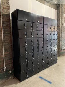 A large black metal locker with many locks.