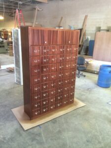 A large wooden cabinet with many drawers on top of it.