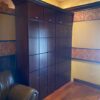 A room with many wooden cabinets and a leather chair.