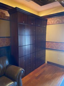 A room with many wooden cabinets and a leather chair.