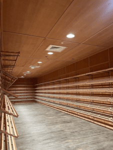 A large empty room with wooden shelves and lights.