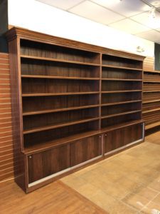 A large wooden bookcase in the middle of a room.