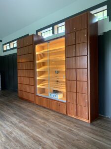 A room with a large wooden cabinet and glass doors.