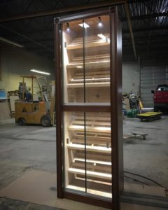 A tall wooden cabinet with lights on top of it.