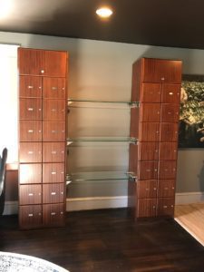 A large wooden cabinet with glass shelves and drawers.