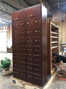 A large wooden cabinet with many drawers in it