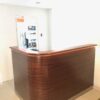 A wooden reception desk with a phone on top of it.