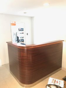 A wooden reception desk with a phone on top of it.