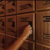 A person is pushing the key to the wooden cabinet.