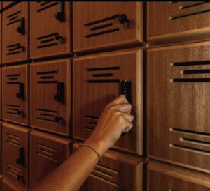 A person is pushing the key to the wooden cabinet.