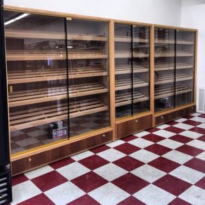 A room with three shelves of cigars on the floor.