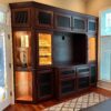 A large entertainment center with glass doors and drawers.
