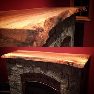 A fireplace mantle with a slab of wood on top.