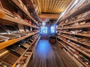 A long wooden shelf filled with lots of cigars.