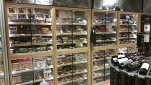 A store with many glass cases filled with different types of cigars.