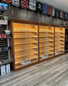 A large display case with shelves of cigars.