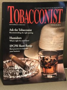 A magazine cover with a glass of whiskey and a cigar.