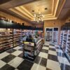Custom commercial walk-in humidor with Spanish cedar display racks, center gondola, overhead storage, and integrated LED lighting